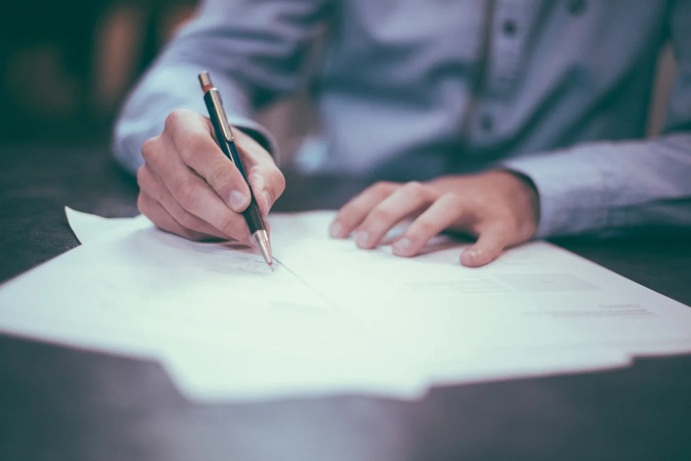 Business owner working through financial paperwork by hand at a desk